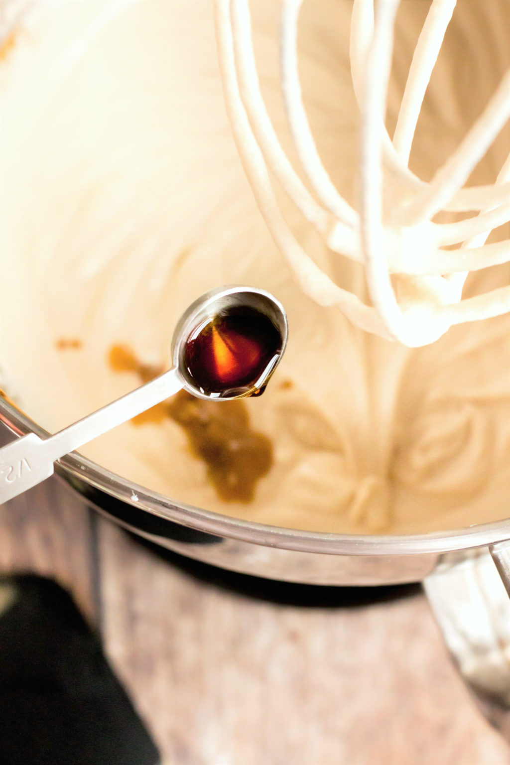 Vanilla is poured into cream mixture.