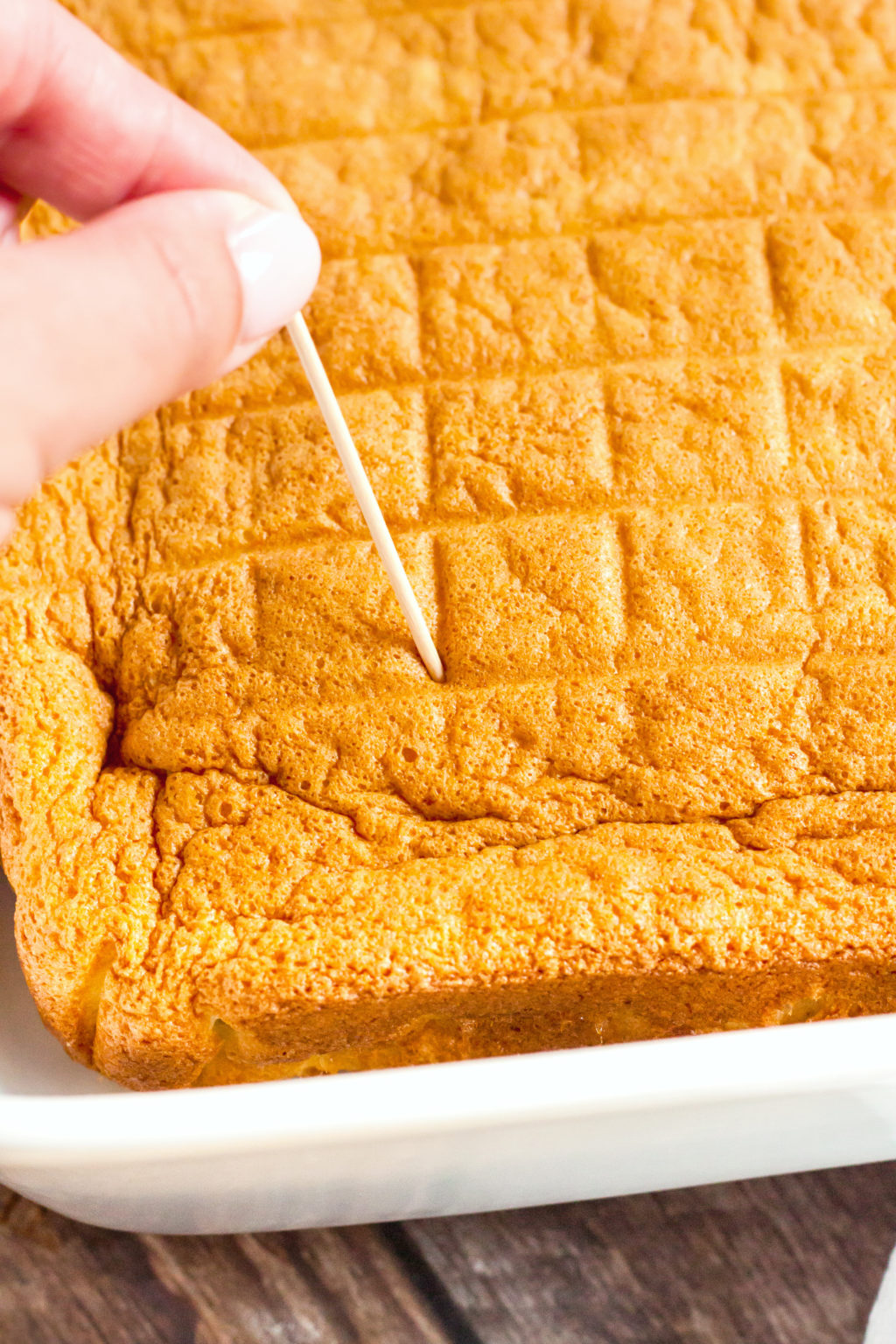 Cake is poked with a toothpick to allow liquid to soak into the sponge.