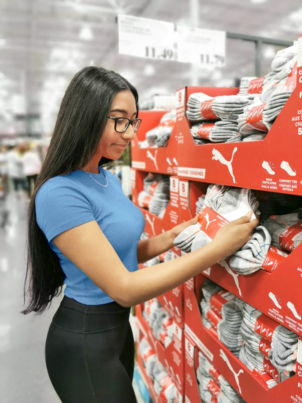 Gabby browses the socks in Costco, she stops at the Puma socks.