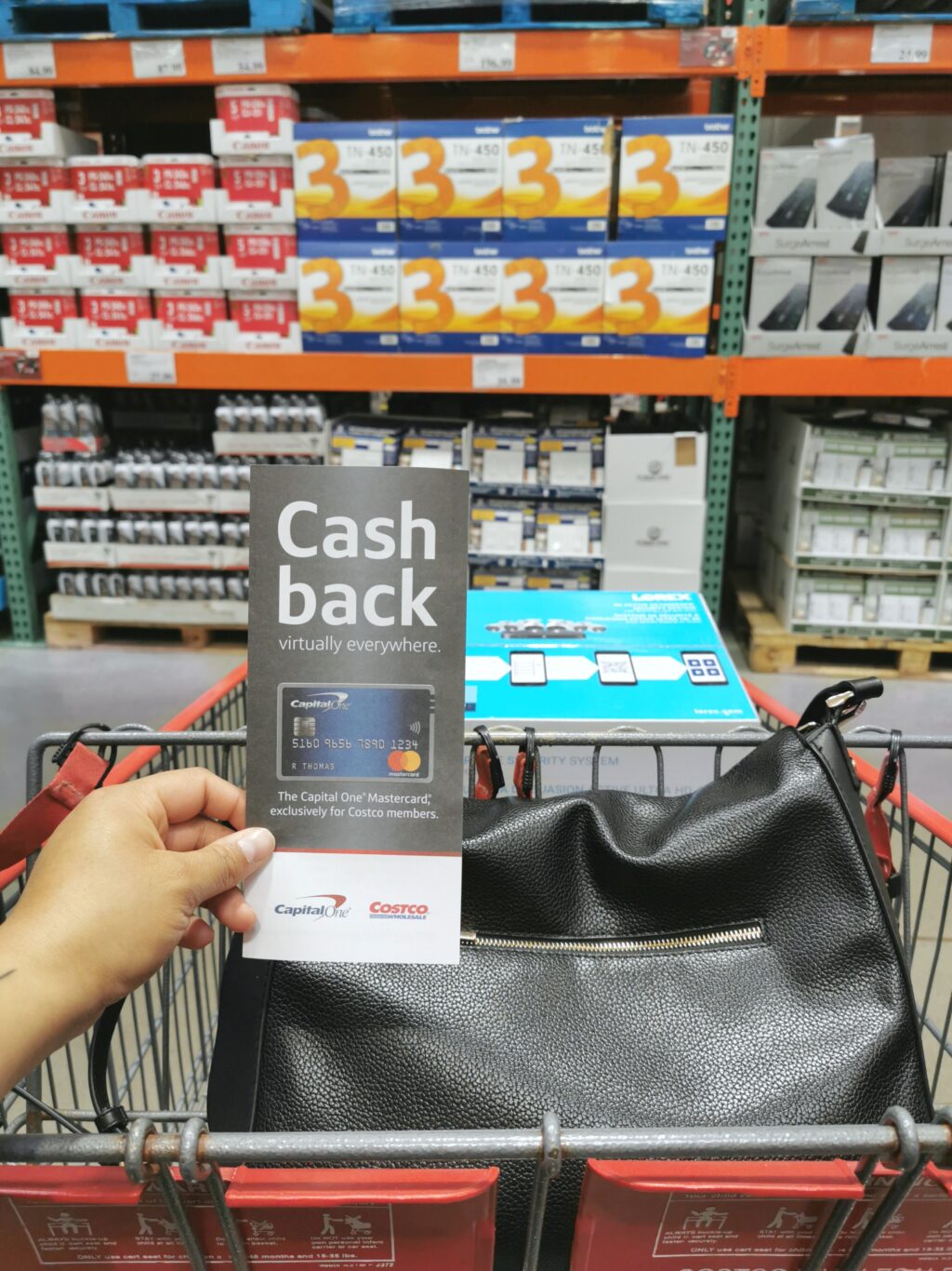 Nancy holds a brochure for Capital One's Costco credit card while she shops. 