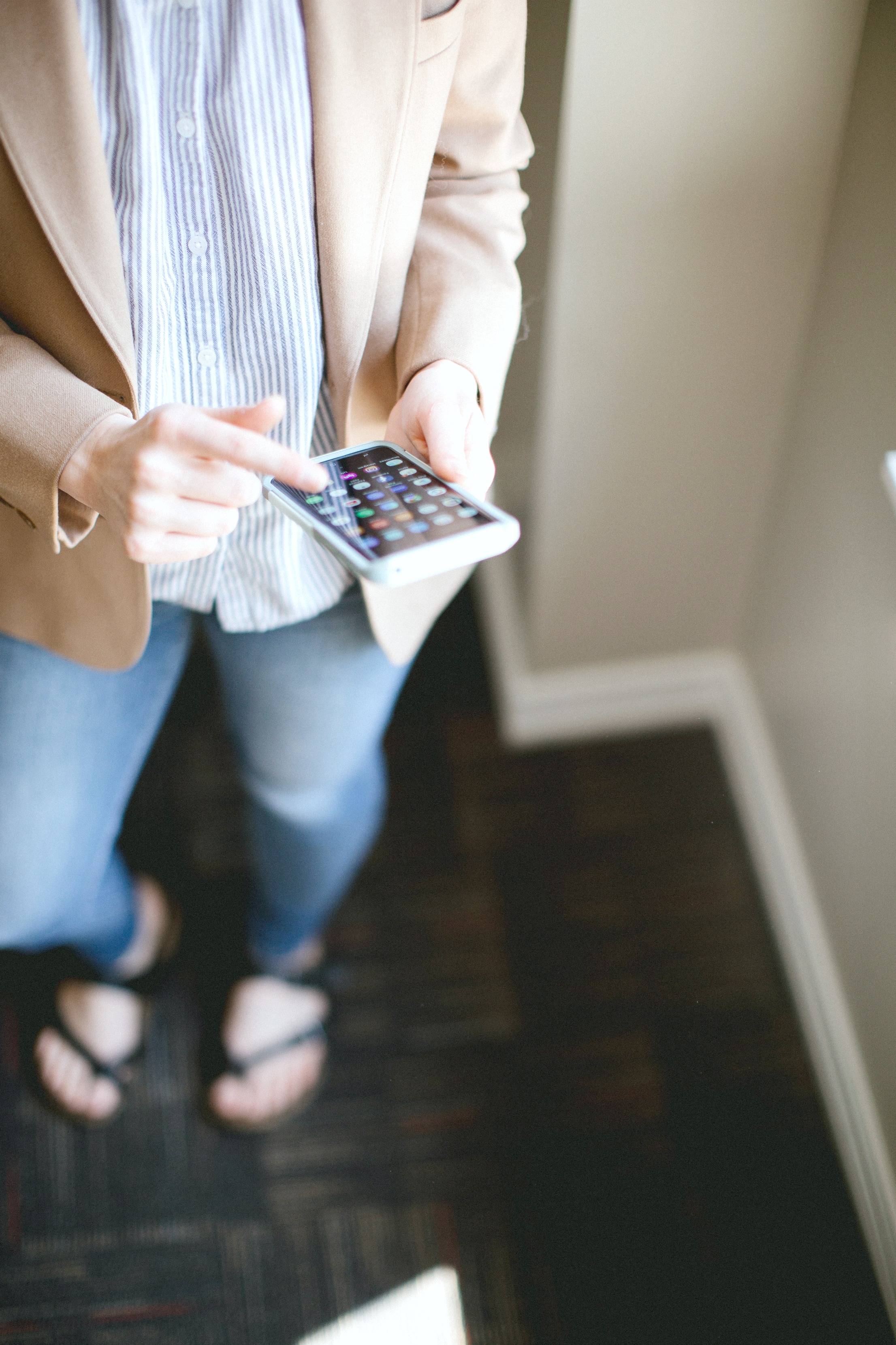 Woman using her phone to control her smart thermometer. 