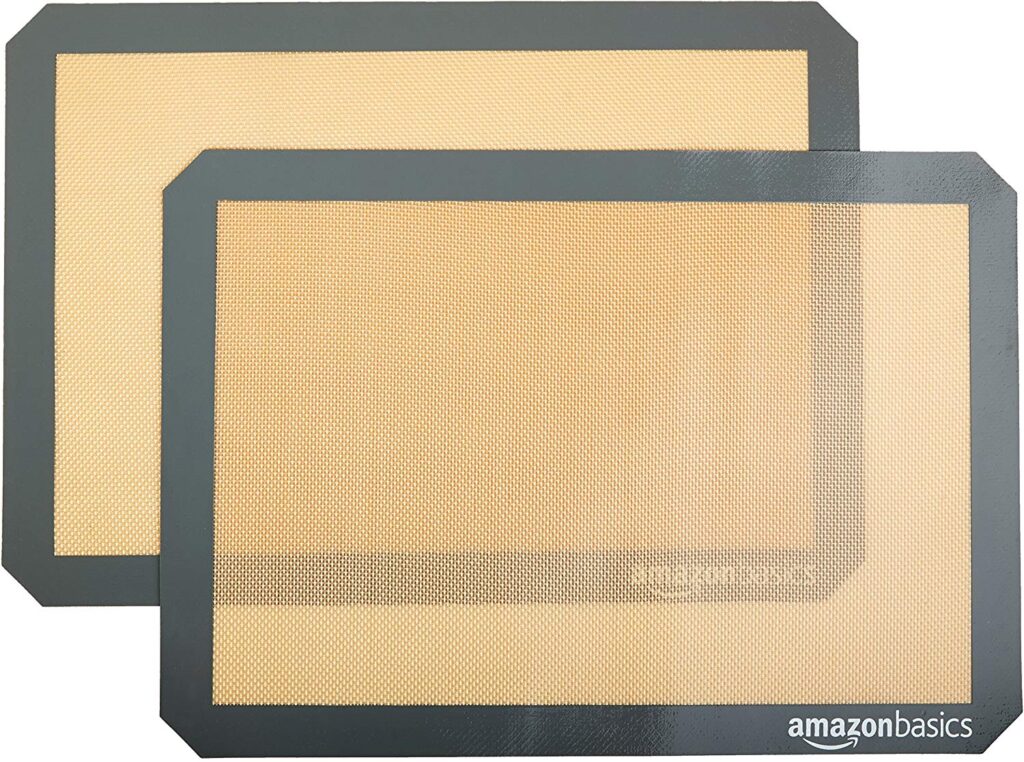 Two light orange and grey silicone baking mats from Amazon Basics.