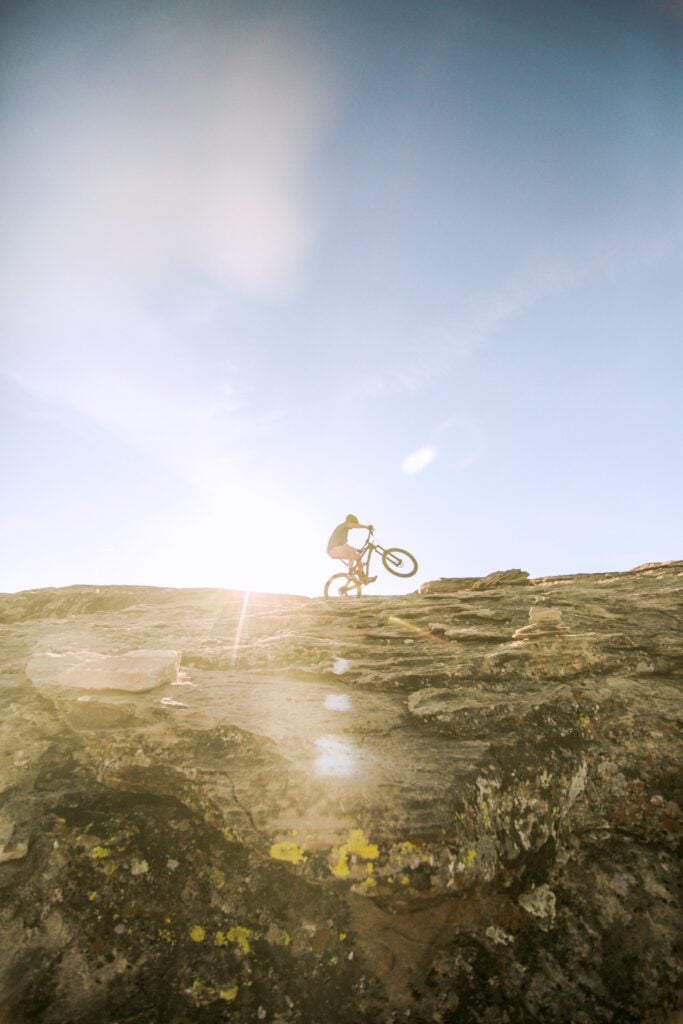 A cyclist is on a mountain riding his bike. Have you ever thought of taking a cycling vacation? If not, why not? If you're an active and outdoorsy person, you can see your destination in a unique way. #packingtips #traveltips