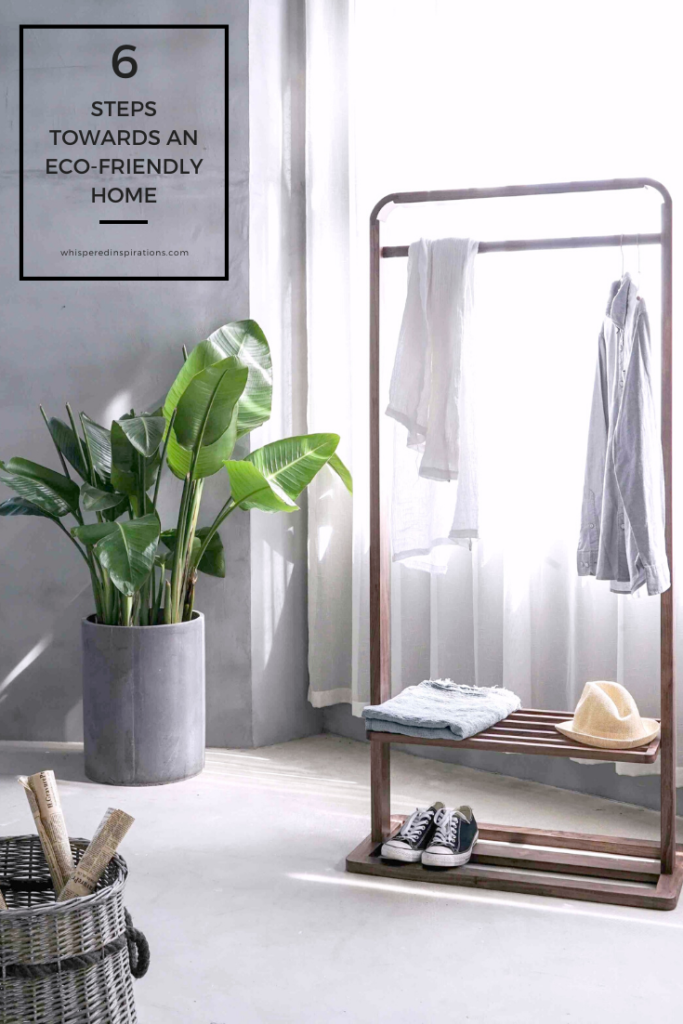 A gorgeous bedroom that has a wooden clothes rack and plants. A banner reads, "6 steps towards an eco-friendly home."