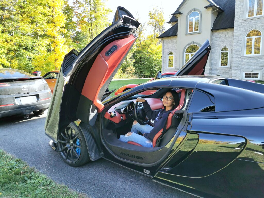 Gabby in the driver seat of a McLaren.