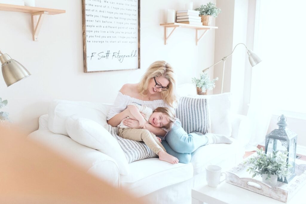 Woman and her son sit on the couch in their warm and inviting living room.