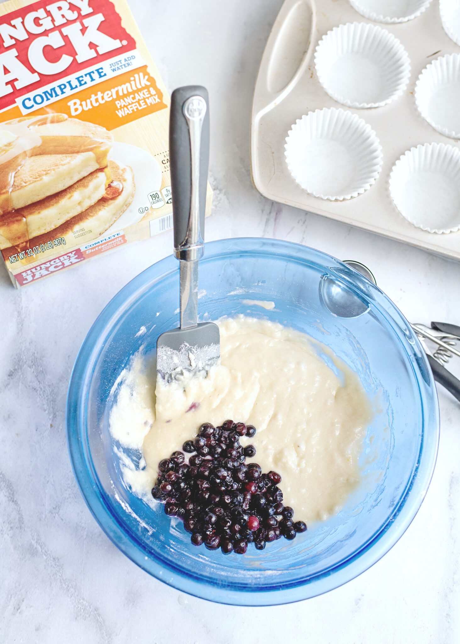 The blueberries are added to the batter. 