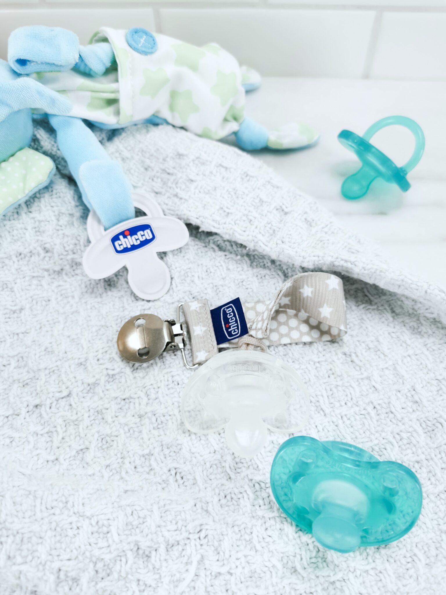 A close up of Chicco pacifiers and holders. 