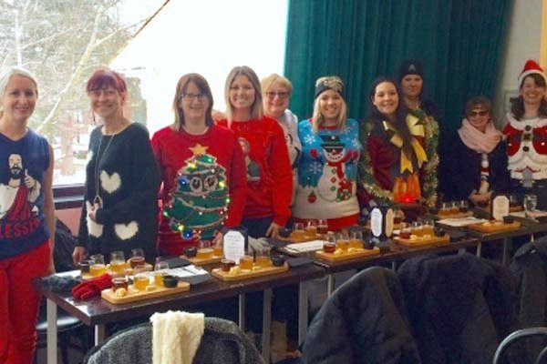 A group of women in ugly Christmas sweaters doing a food tour in Niagara.