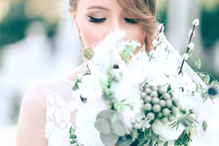 Beautiful bride holds her bouquet close and closes her eyes.
