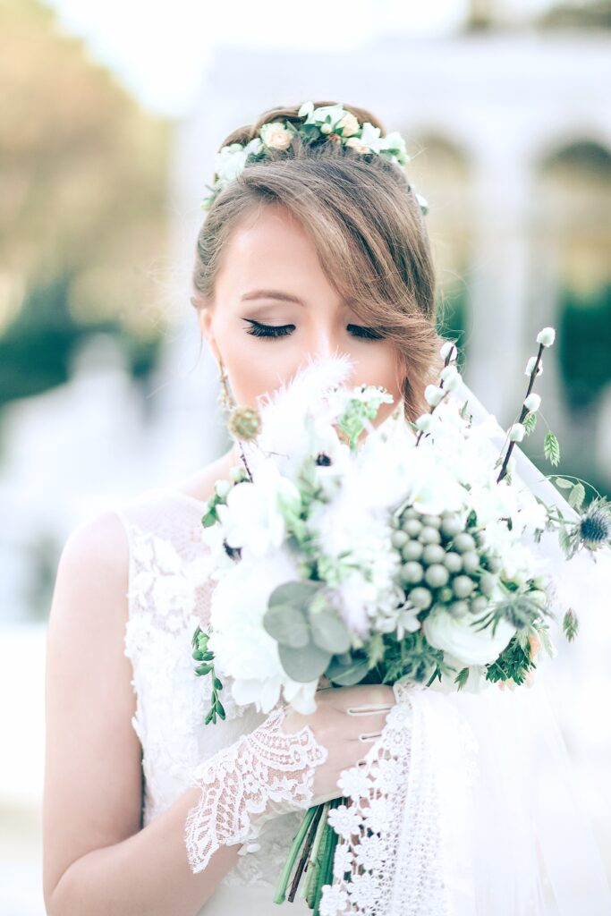 Beautiful bride holds her bouquet close and closes her eyes.