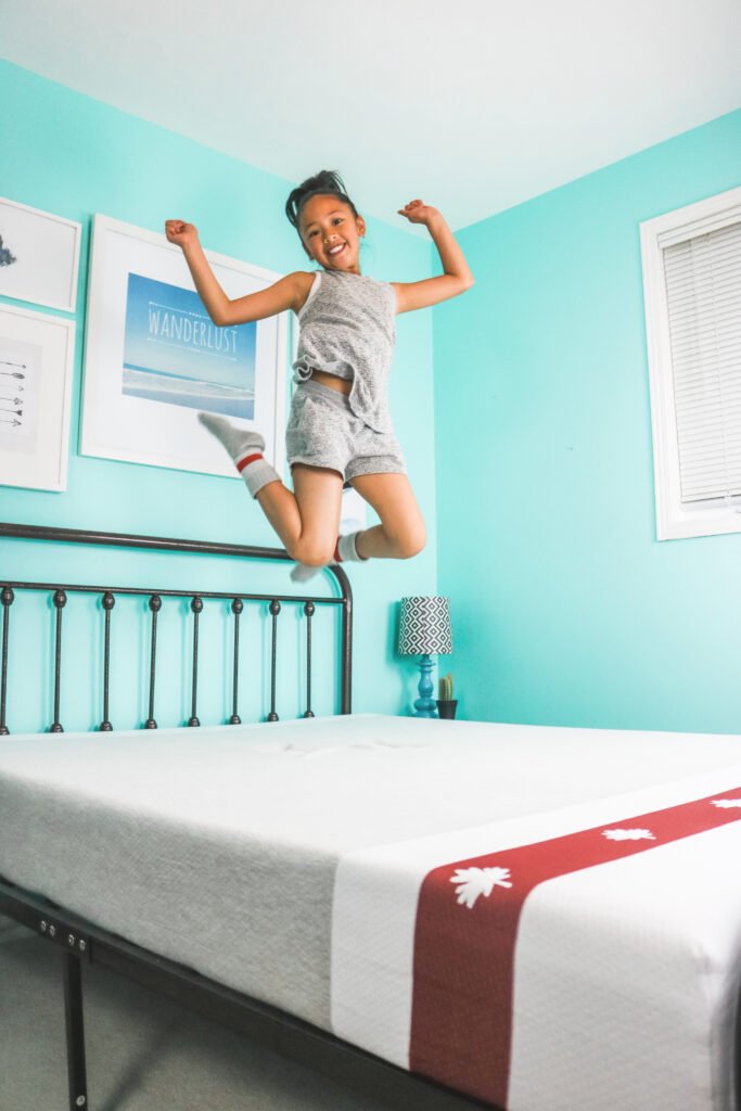 Mimi jumps in the air from her Juno mattress. 
