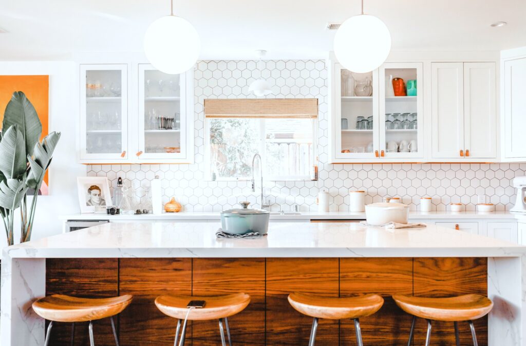 A modern white kitchen with warmth added in via natural wood.