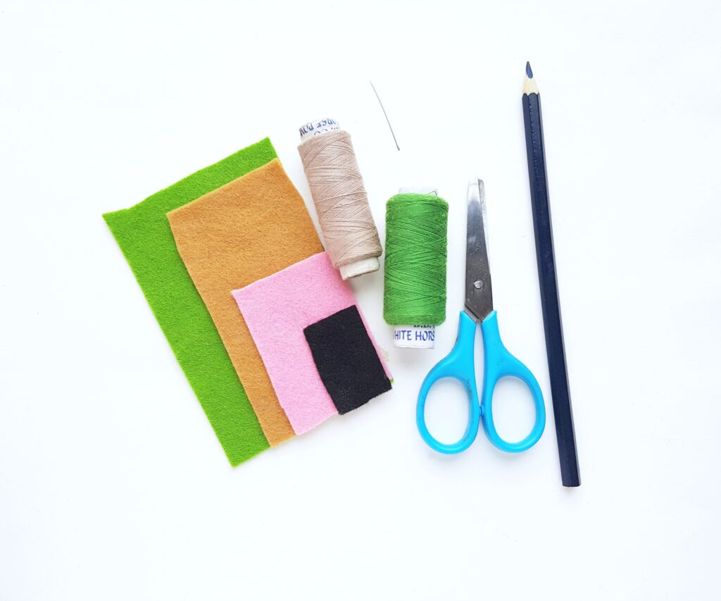 Supplies needed to make a Baby Yoda plushies. Felt, thread, scissors, pencil, and a needle. 