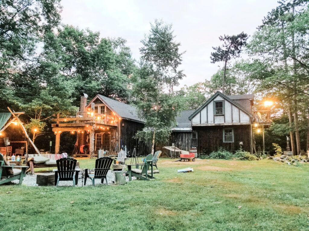 A beautiful backyard with a fire pit and pergola. There are string lights adorning the homes.