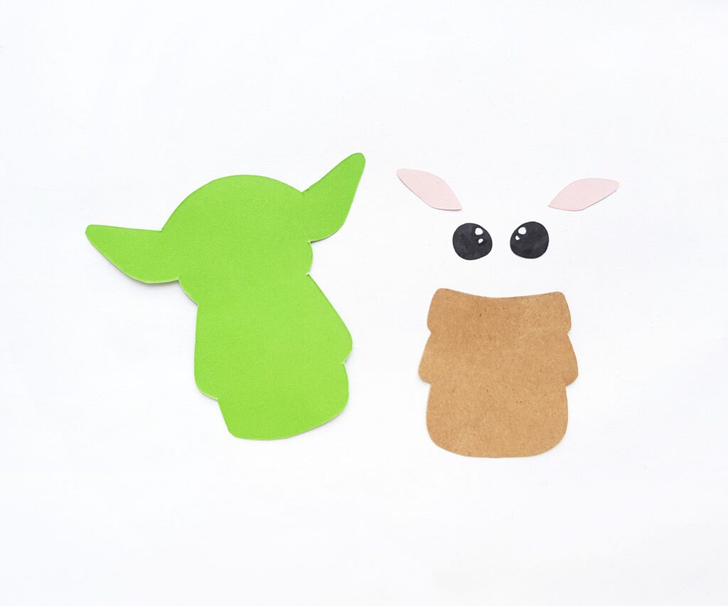 Cardstock paper cut out into Baby Yoda using template. 