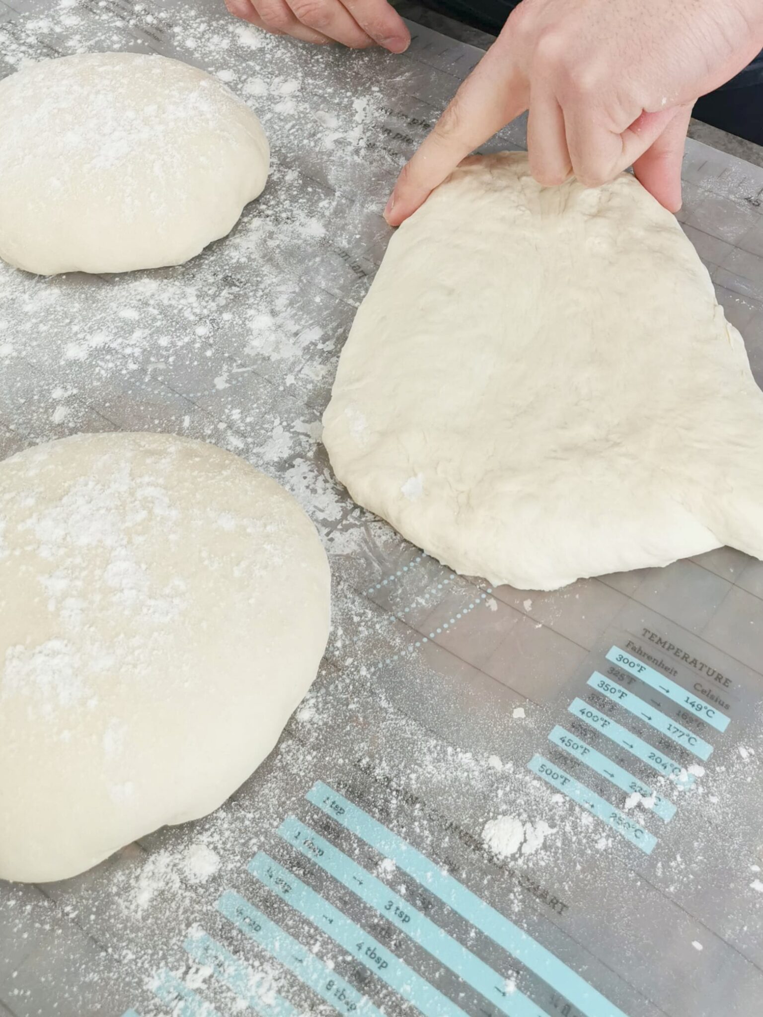 Dough being shaped into triangle shapes prior to shaping into loaves.