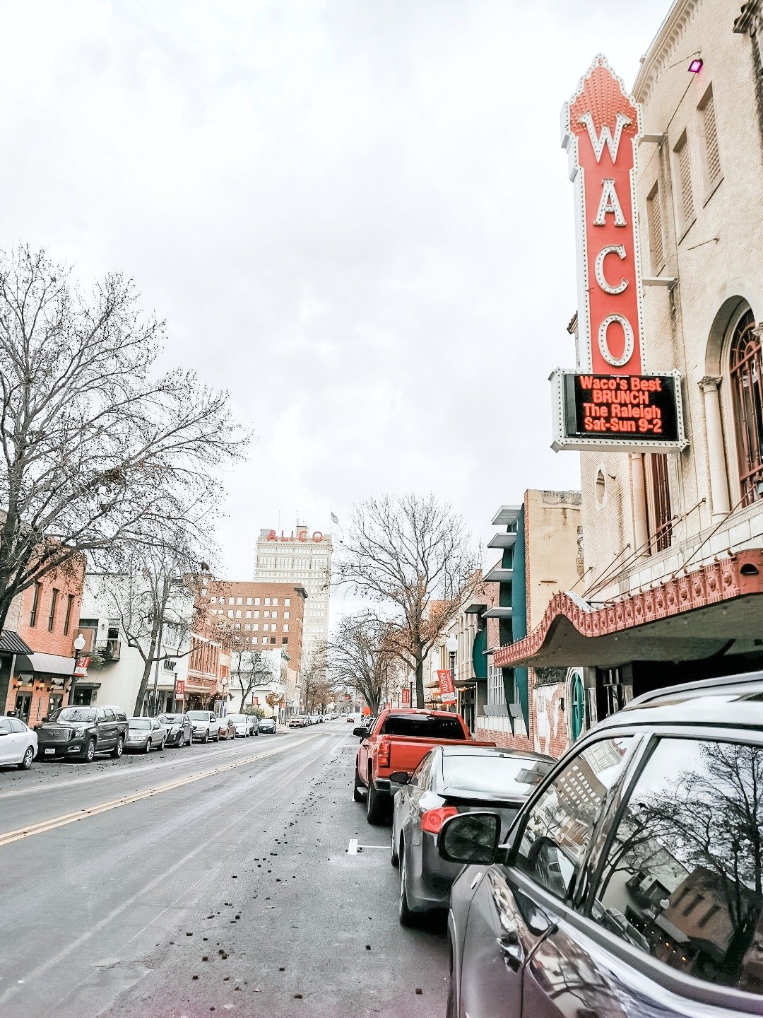 The streets of Downtown Waco, Texas. An empty streets with parked cars in front of the Waco theatre.