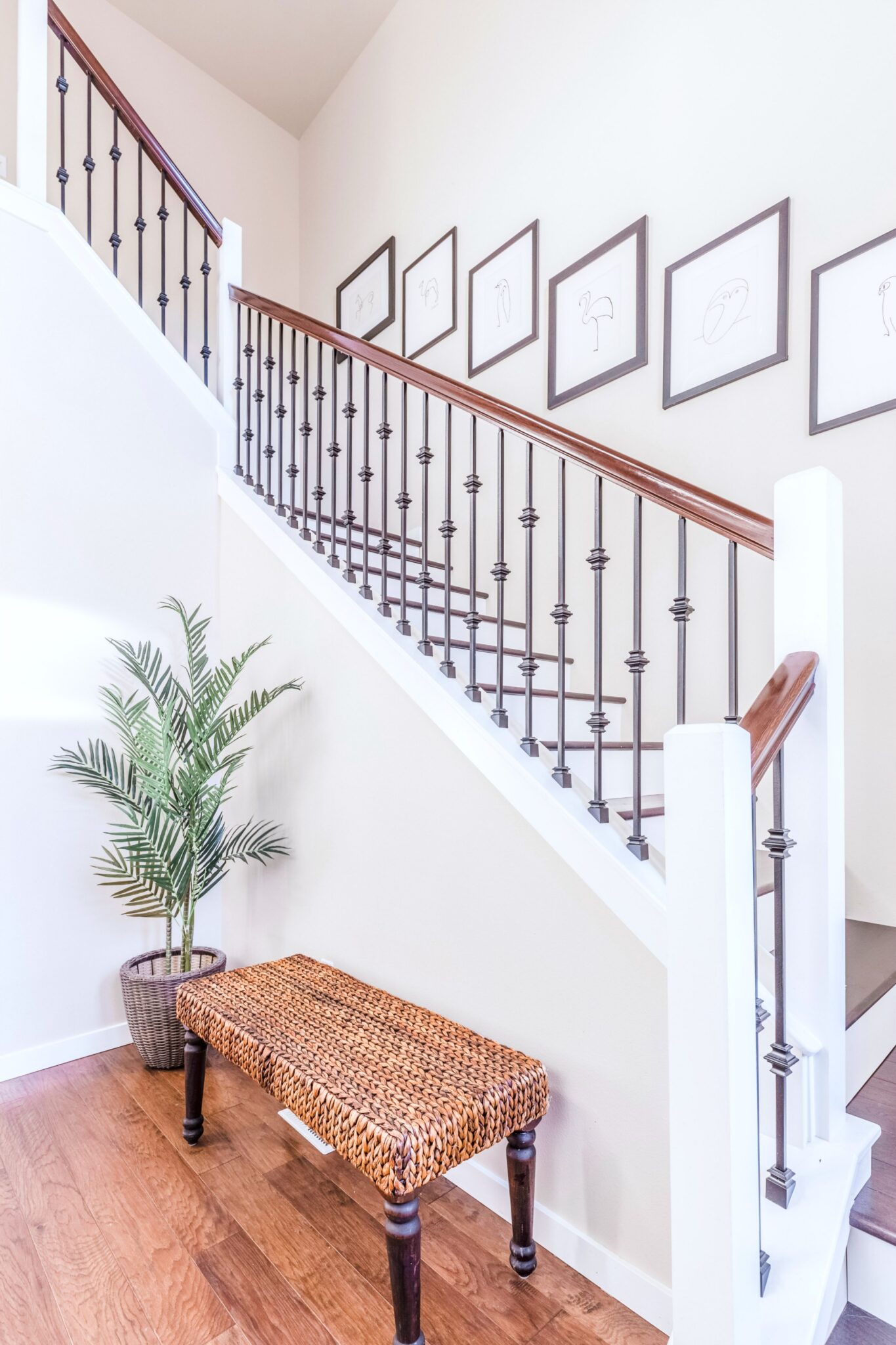 A beautiful staircase with a bench and houseplant. This article is about the best upgrades for first time homeowners. 