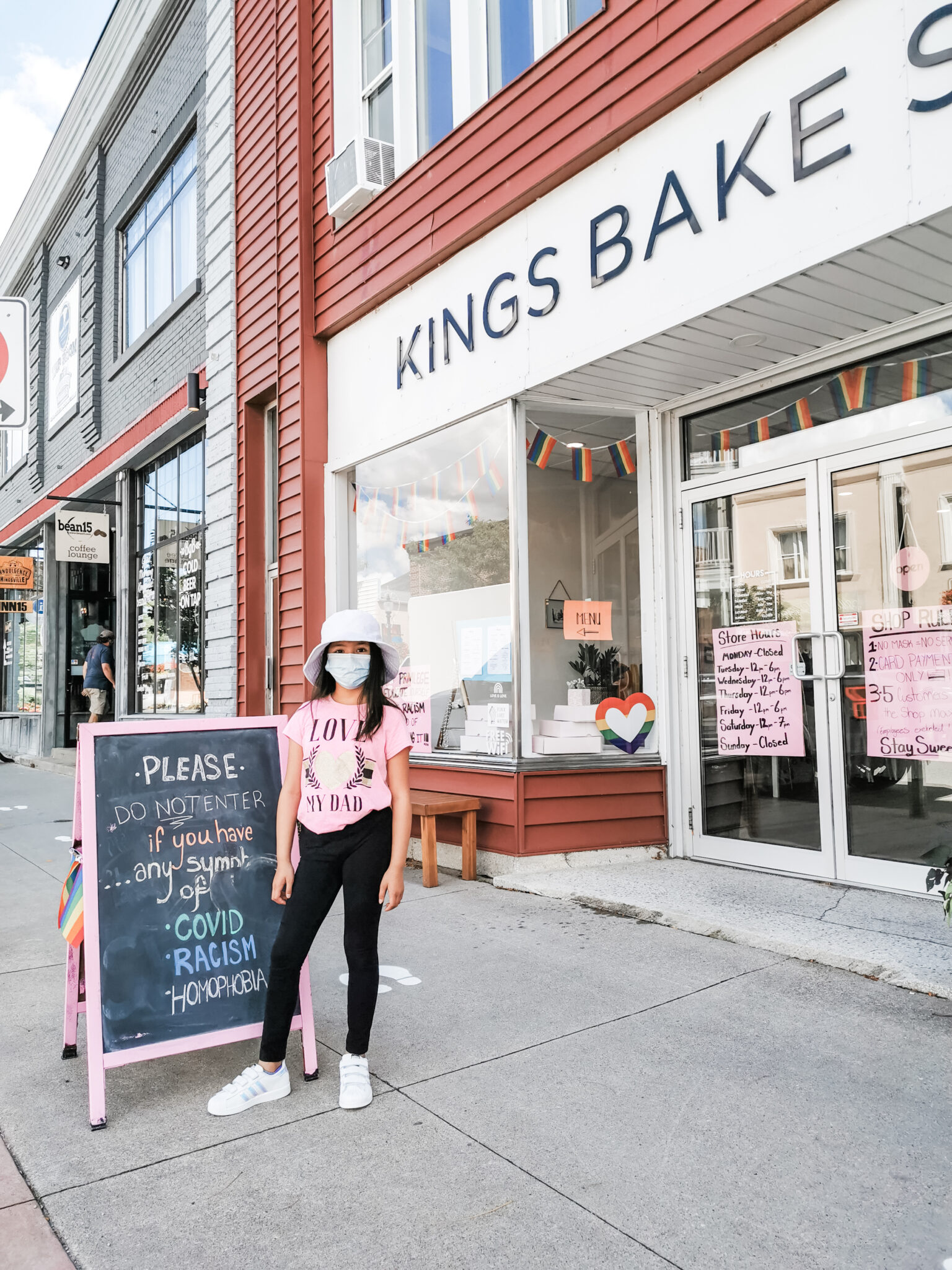 Mimi wearing a mask in front of King's Bakery.