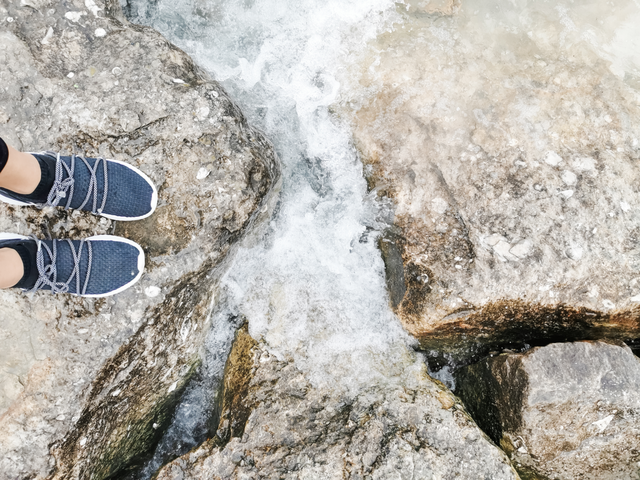 Nancy's feet in between two stones on Lake Huron.