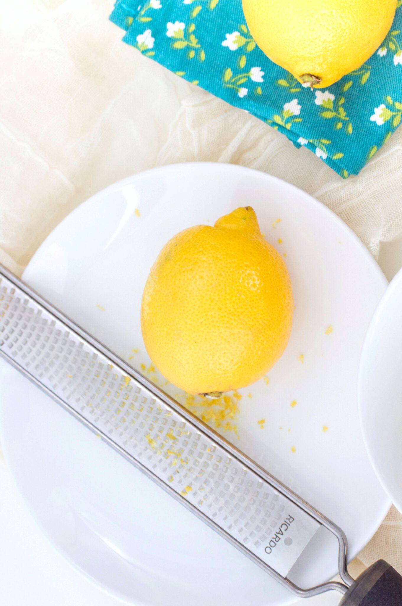 Lemon on a plate being zested for the Mini Lemon Meringue tarts.