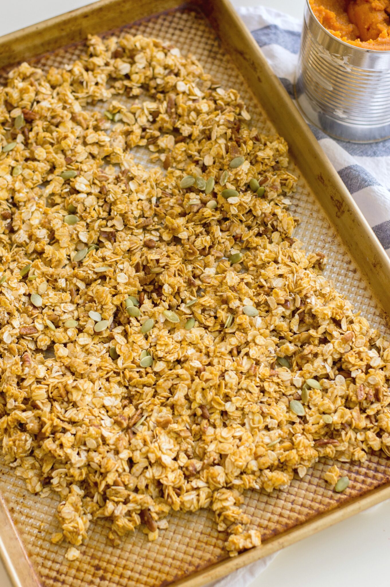 A tray of prepared and baked Pumpkin Maple Pecan granola on a baking sheet.