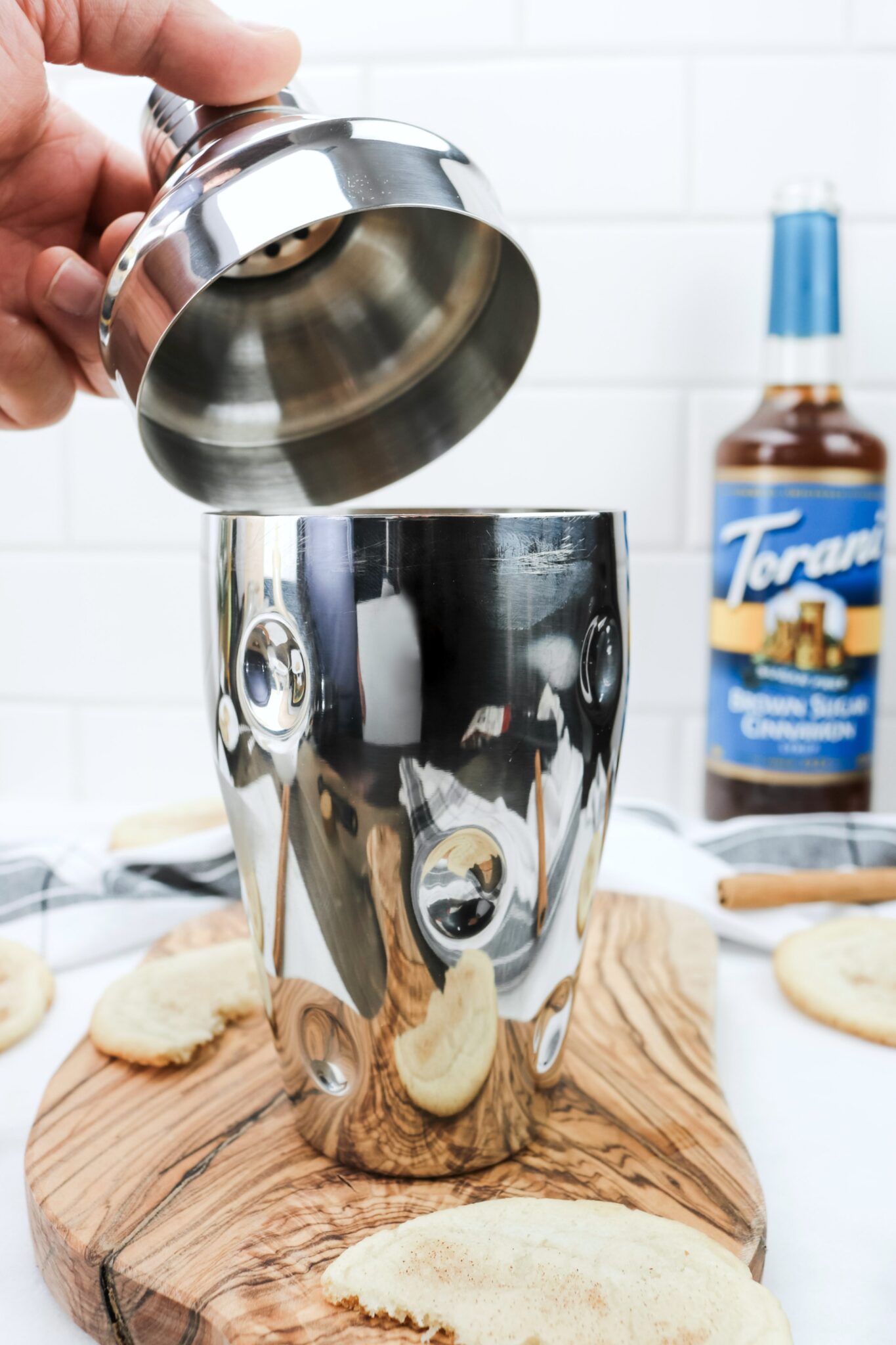 Closing the shaker with all the ingredients to make a Caramel Snickerdoodle Mocktail made with Torani Sugar-Free Brown Sugar and Cinnamon syrup.