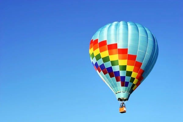 A hot air balloon ride against a blue sky. One of many socially-distanced experiences to enjoy.