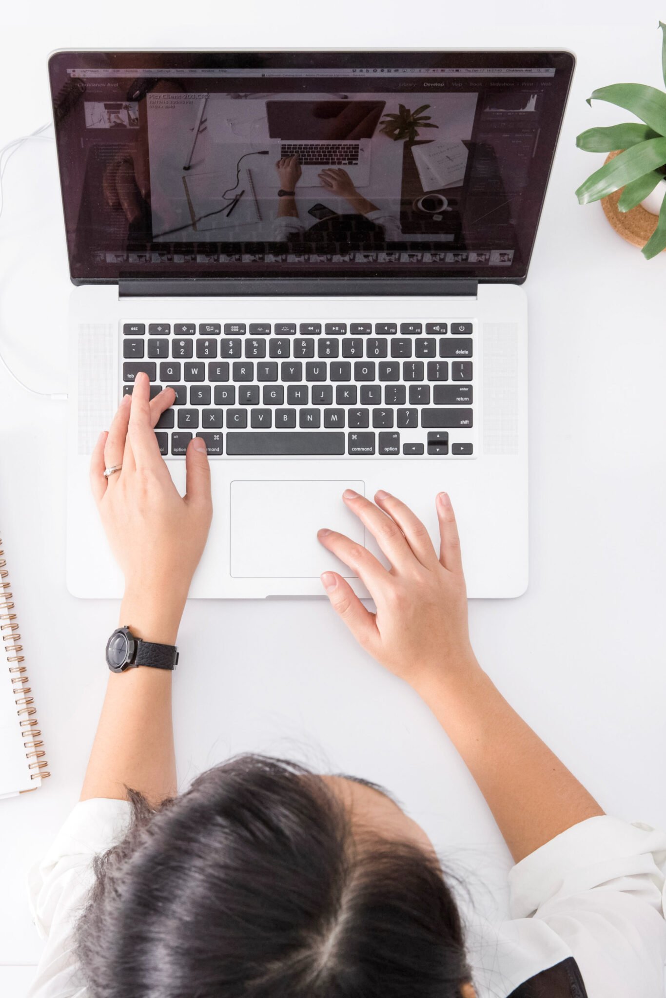 A woman types on a computer working in an office setting. This article covers tips on how to improve your concentration at work.