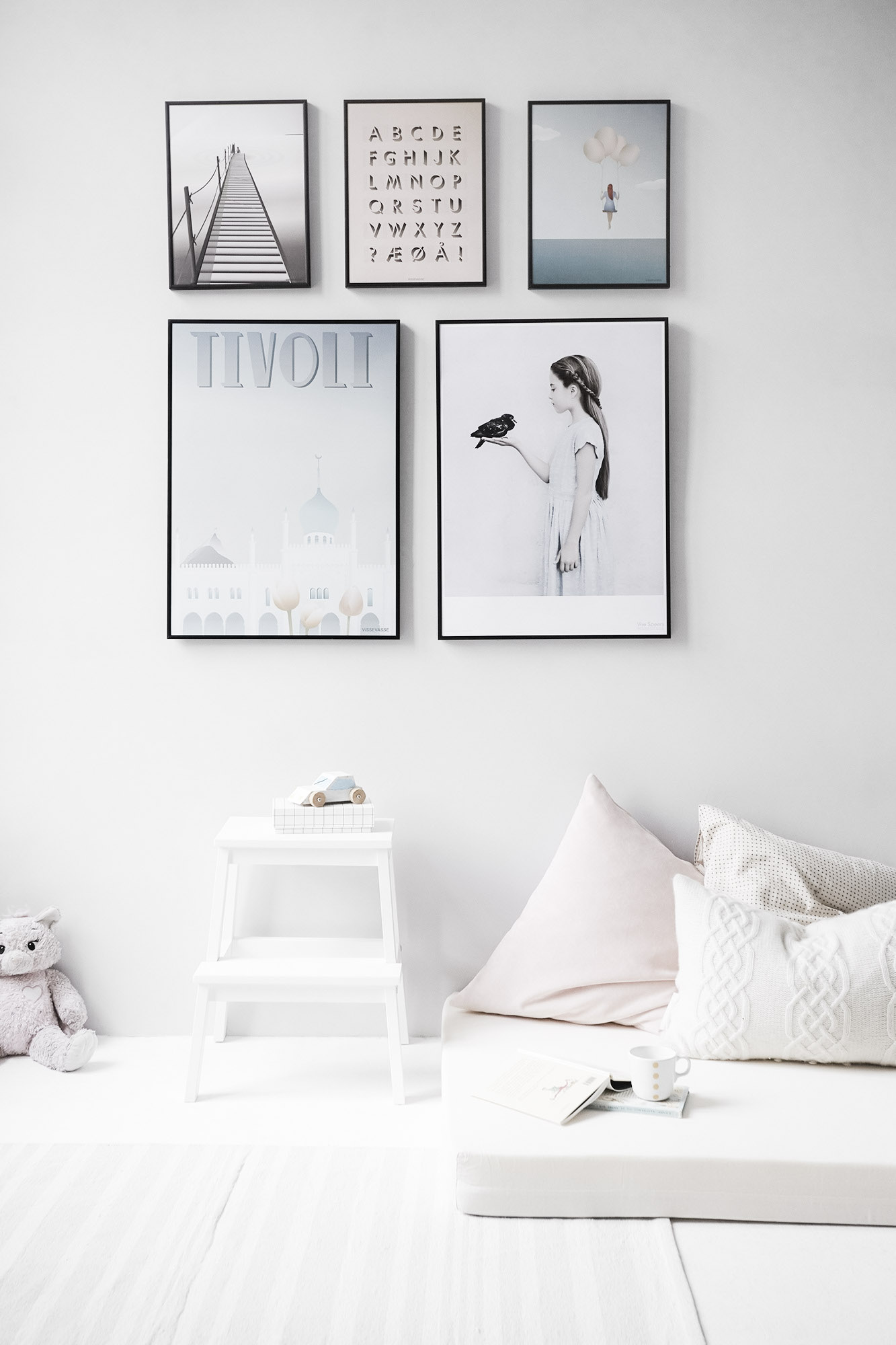 A neutral wall is decorated with several frames with pictures. This article covers how to create the perfect accent wall in your home.