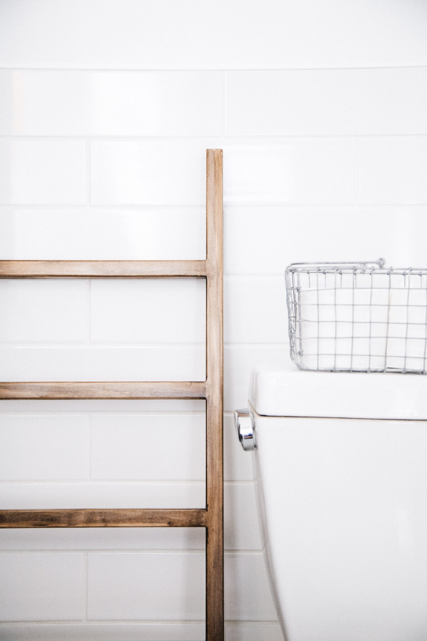 A towel ladder rests next to a toilet. This article covers tips for hiring a plumber.