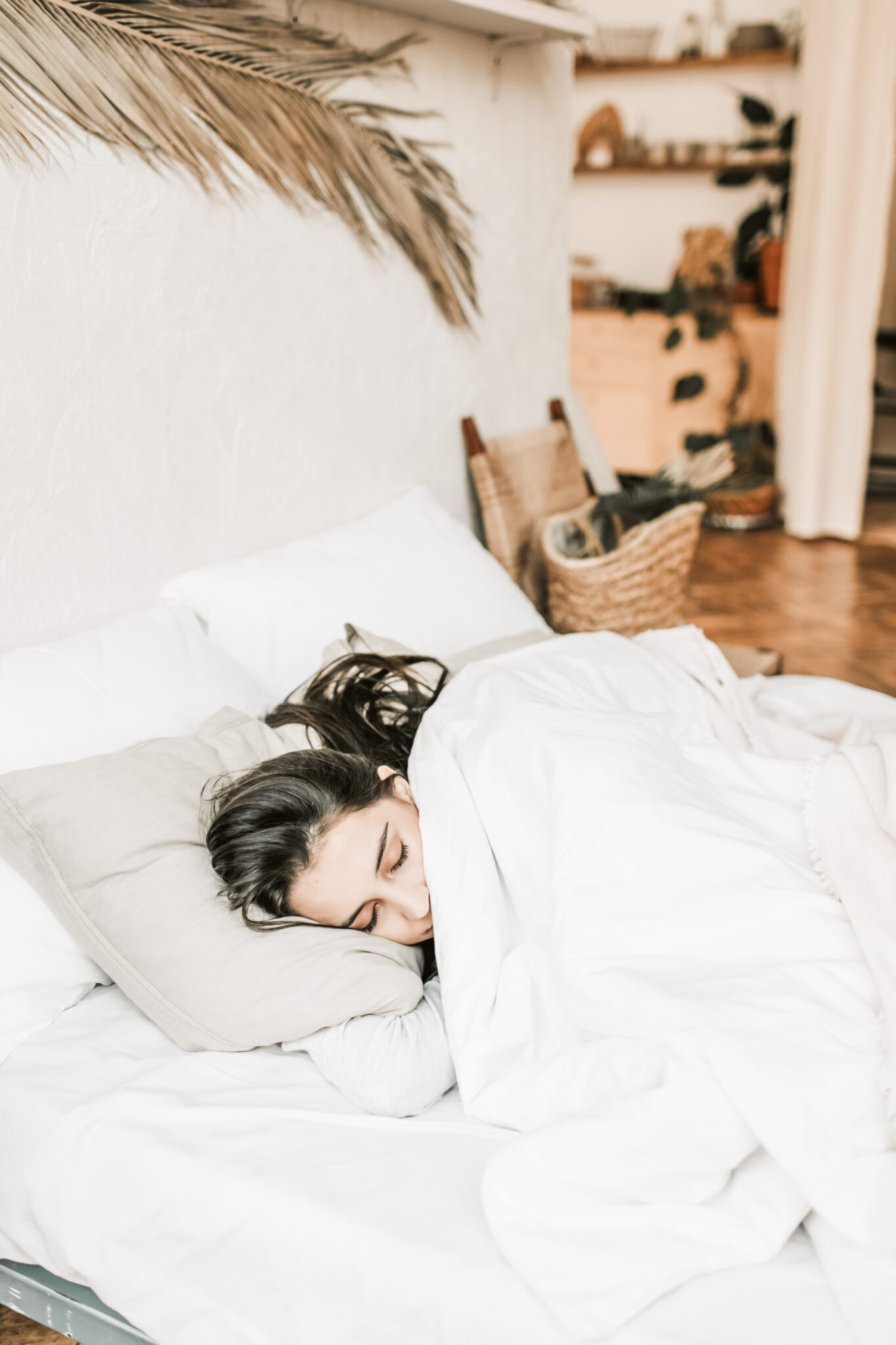 Woman sleeps comfortably in bed. This article covers how to prevent recurring nightmares and sleep better.