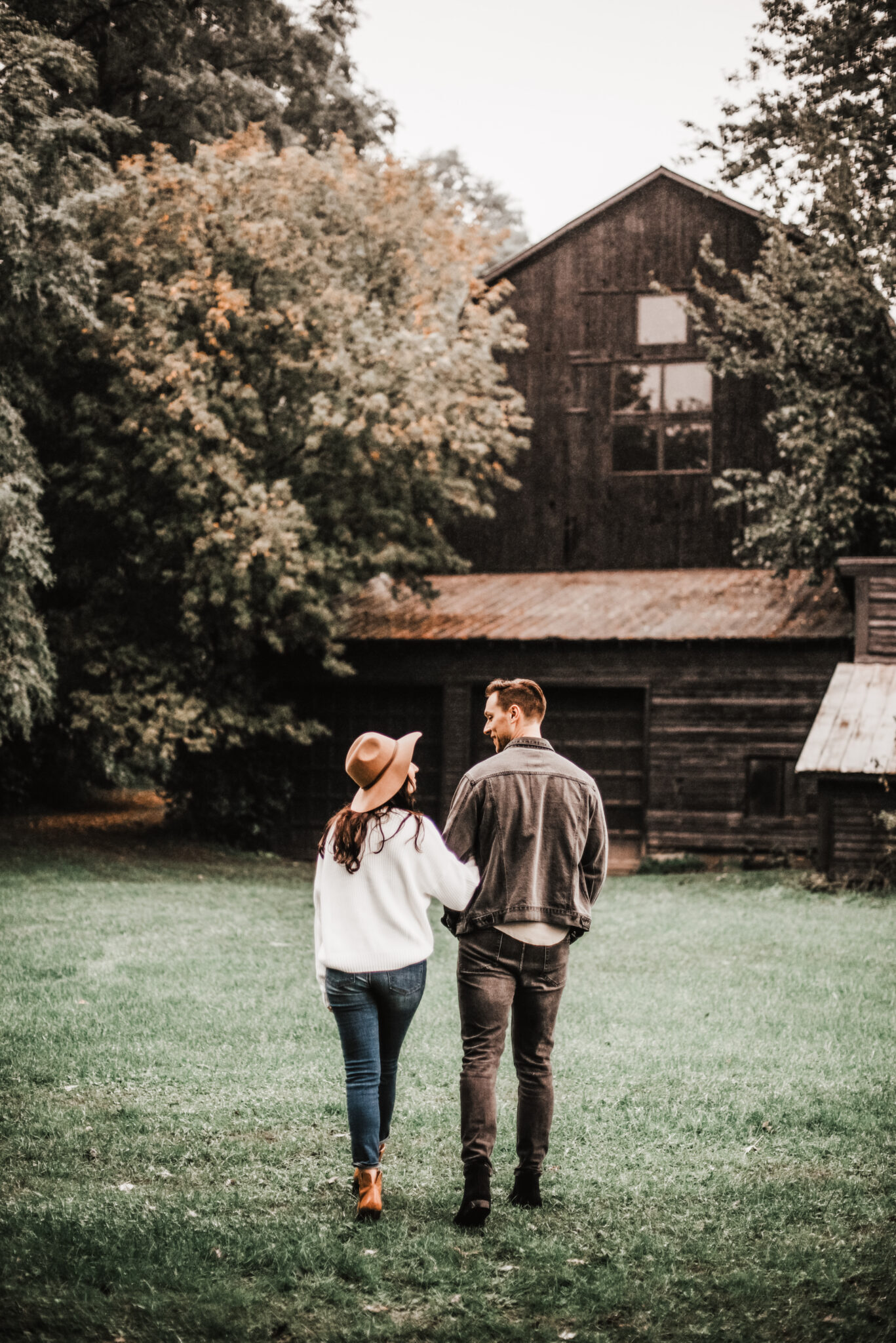 A couple walking towards their rural farmhouse. This article covers how to maximize the benefits of rural living.