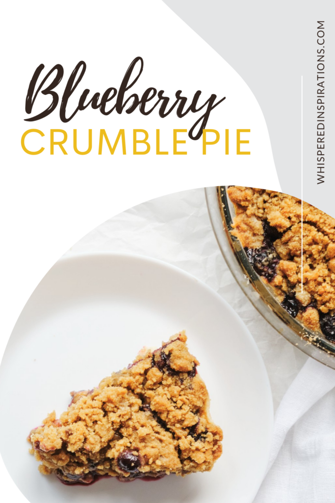 A blueberry crumble pie with a piece missing. The piece of pie is on a white plate on top of a napkin. There is a small bowl of blueberries shown. This article covers a Blueberry Crumble Pie recipe.