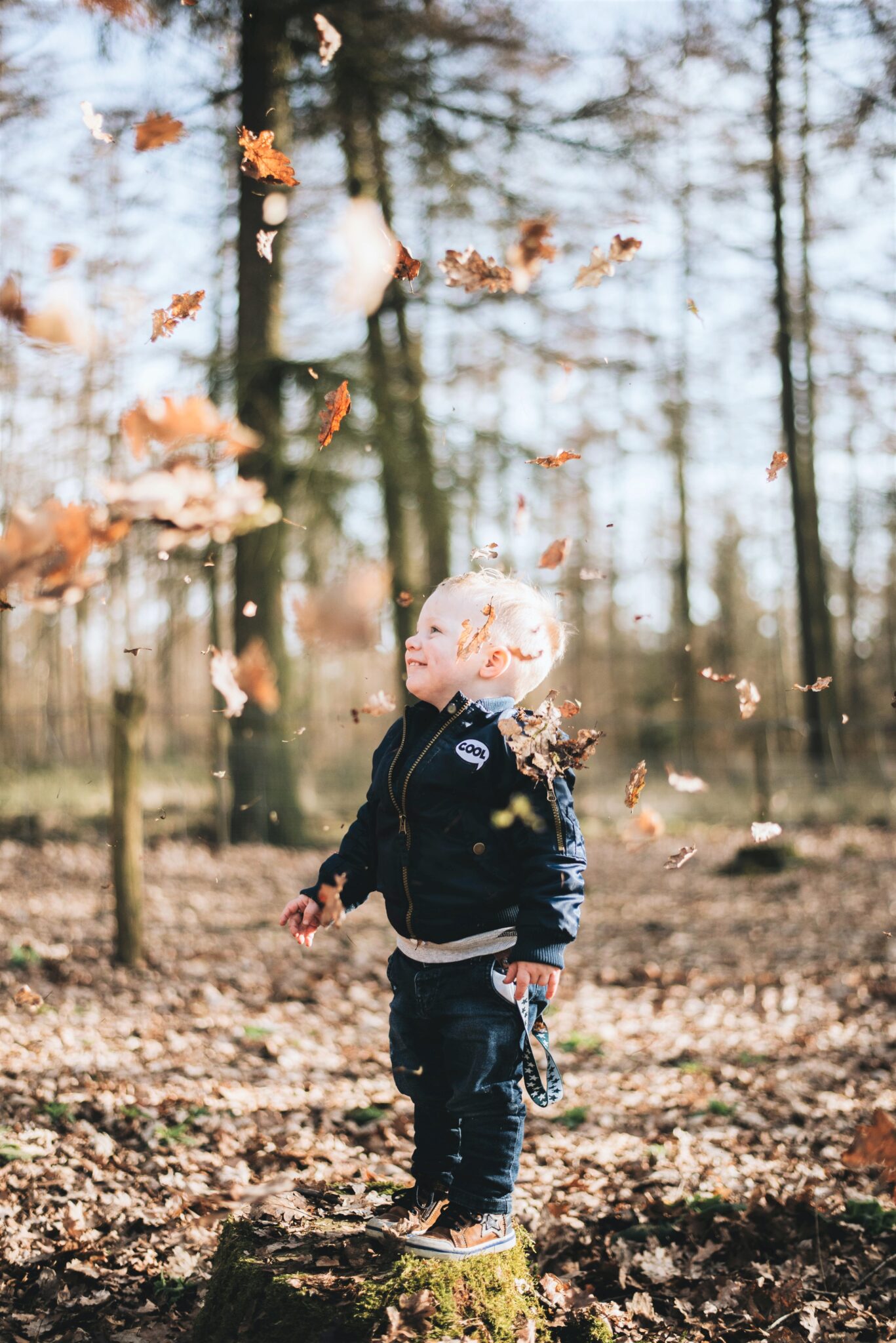 A little boy jumps and plays in fall leaves. This article covers fun outdoor play ideas that nurture imagination and creativity. 
