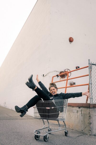 Happy woman in cart. This article covers the art of hacking your online shopping.
