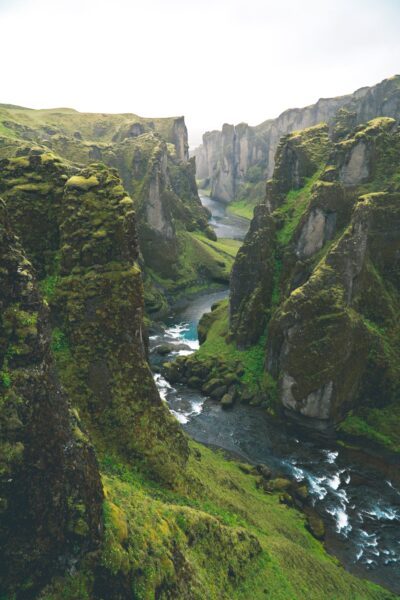 A beautiful landscape with a river running through two large fjords in Iceland. This article covers the questions, to elope or to have a wedding.