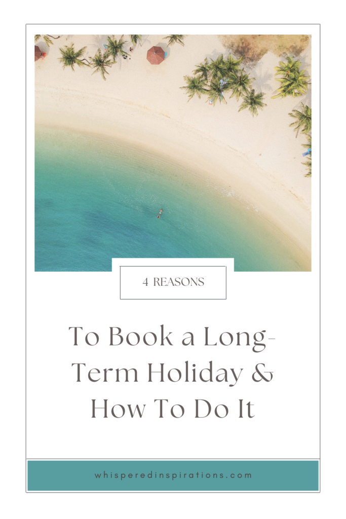 A bird's eye view of a beach, there is a person floating in the water. This article covers reasons to book a long-term holiday.