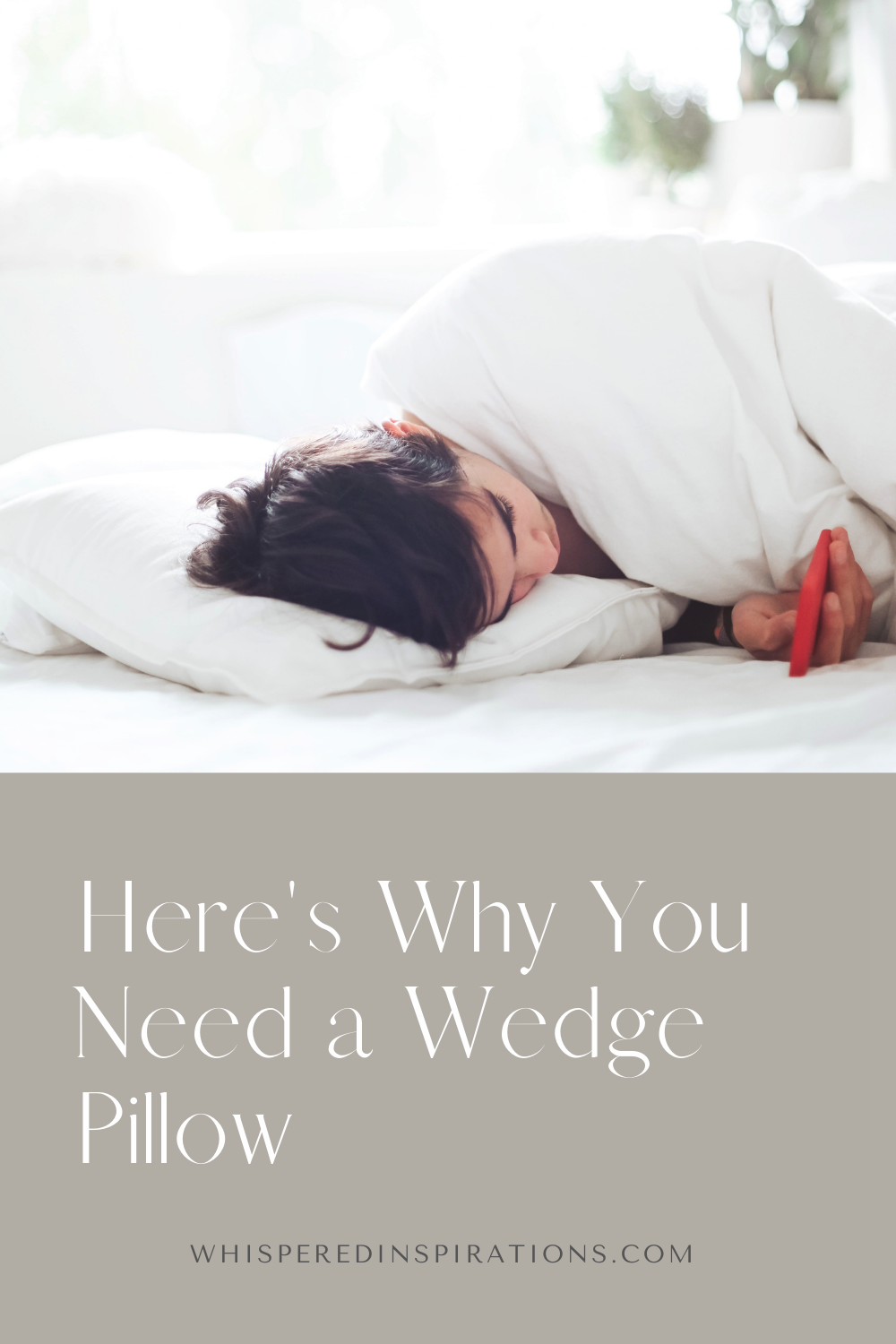 Woman on her phone laying down in bed. The sheets are white and there is a plant behind her. This article covers why you need a wedge pillow.