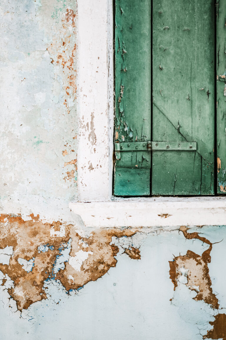 A house and a green window is shown. Both paint are weathered and peeling. This article covers reasons why you should repaint your home.