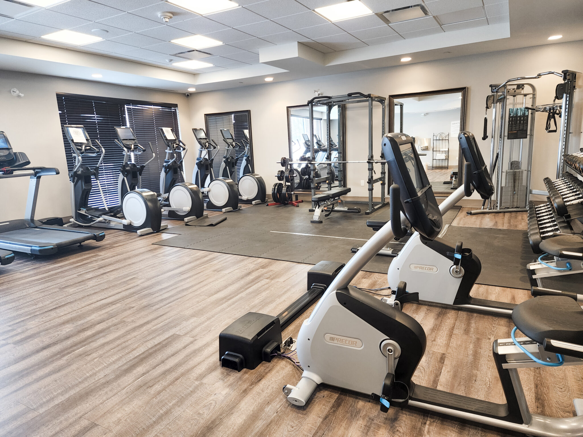 An extensive hotel gym with bikes, treadmills, ellipticals, weights, and smith machines.