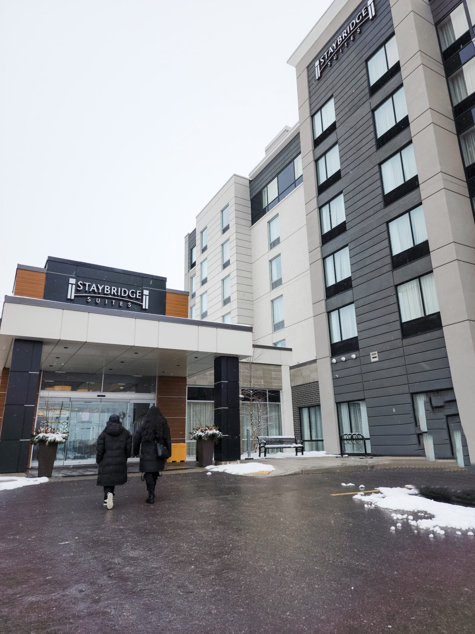Two girls walk towards the Staybridge Suites in Waterloo-St. Jacobs. This article covers how to plan your next ultimate staycation at Staybridge Suites in Waterloo-St. Jacobs.