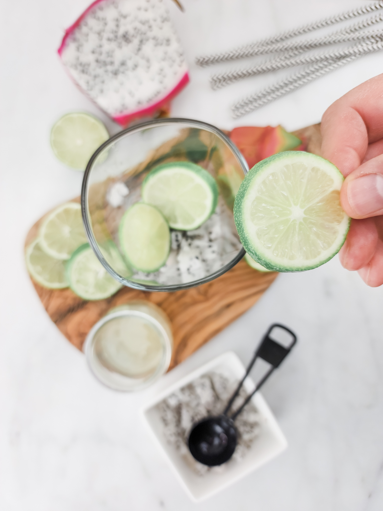 Adding lime slices into the cup on top of the the other ingredients. 