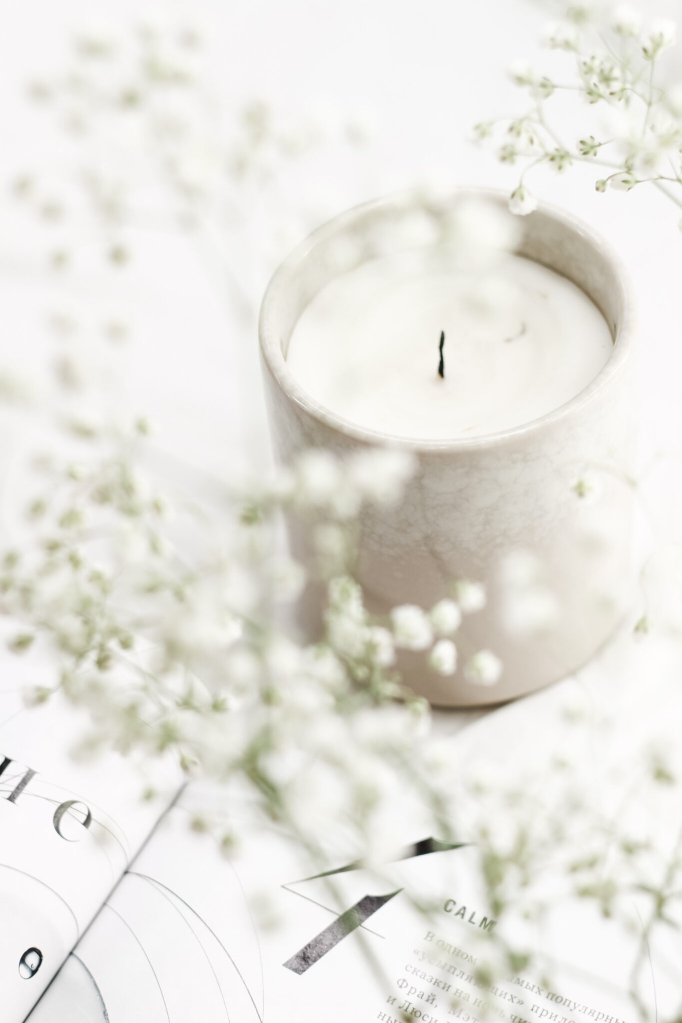 Beautiful little white flowers surround a candle. This article covers meaningful ways to pay tribute to parents.