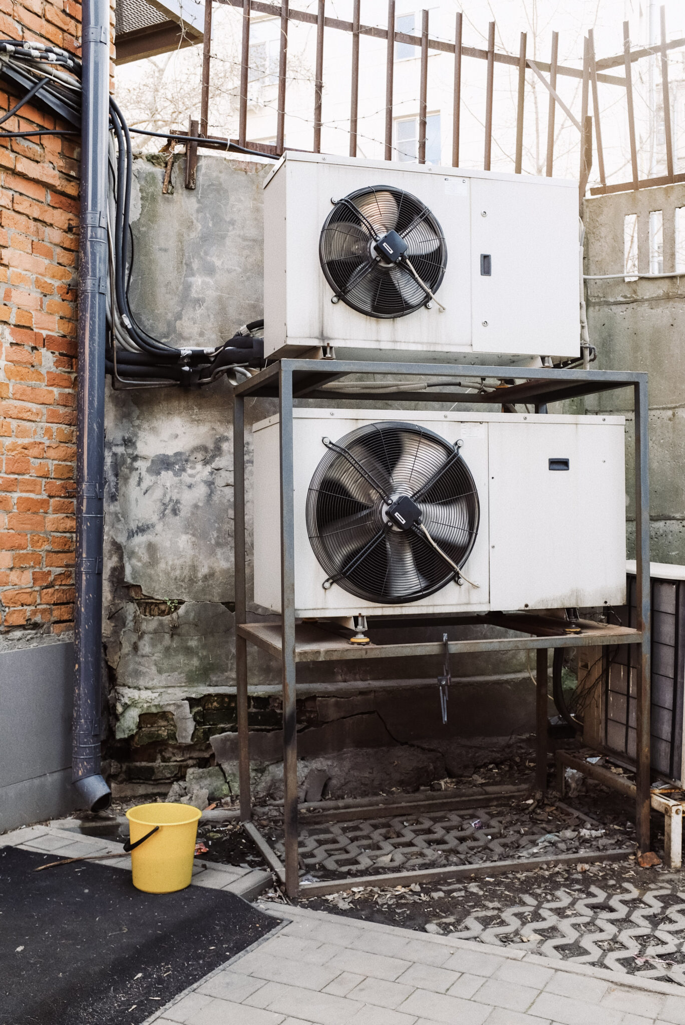 Older AC units outside of an old building. This article covers Lansing MI HVACR and AC Repair near you.