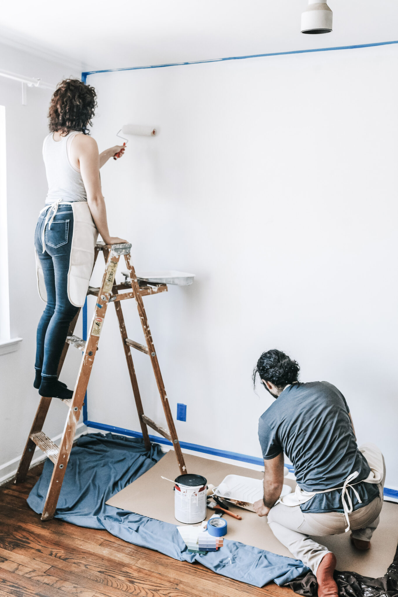 A man and a woman paint a room in their house. This article covers tips for maintaining and improving your family home.