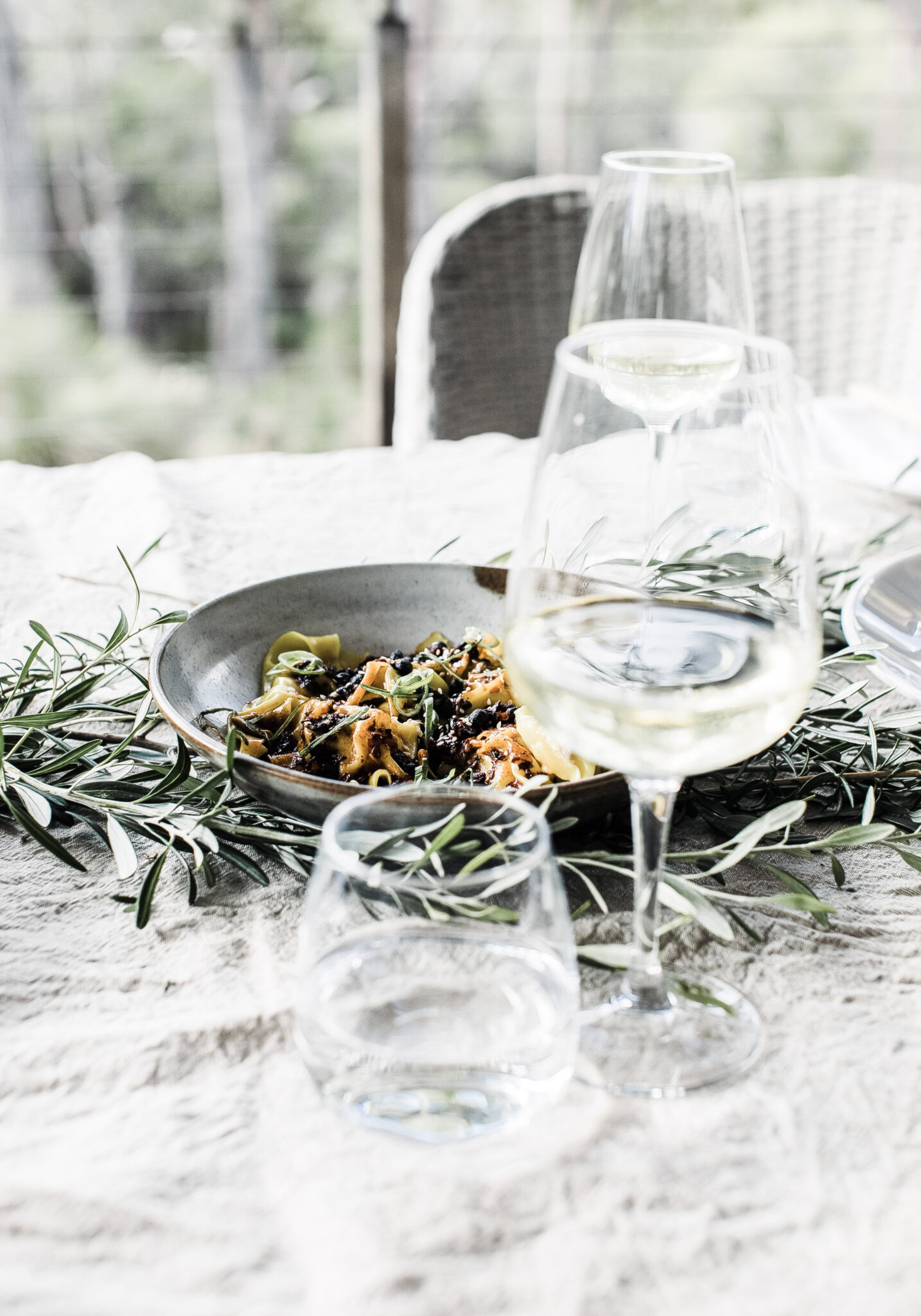 A beautiful tablescape is set up outside. There is white wine and food. This article covers tips on how to combine with different types of food. 