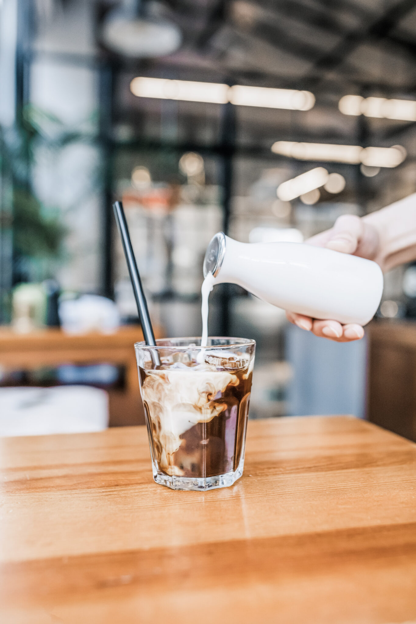 Making an iced latte by pouring cream into a cup of espresso. This article covers how to make Starbucks Caffe Latte.