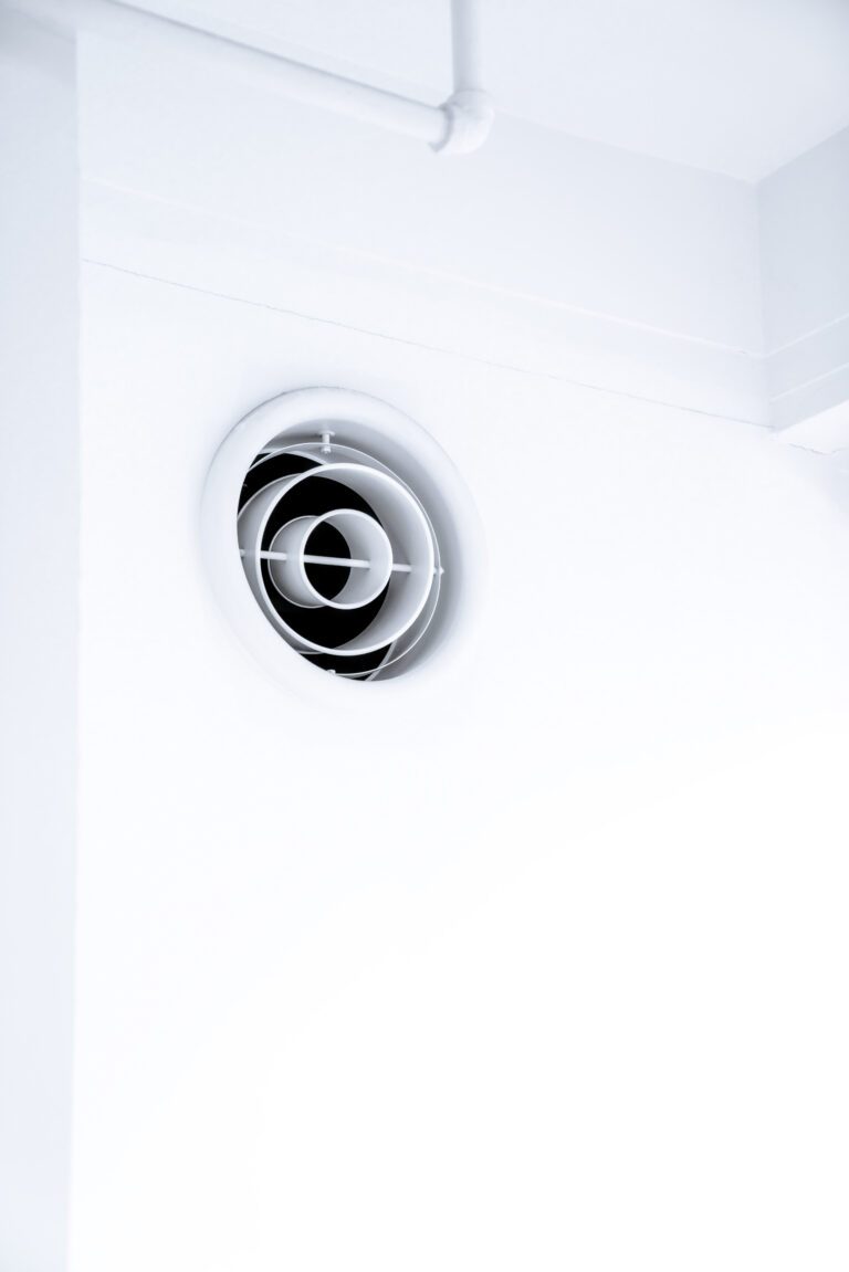An HVAC vent is show against a white wall. This article covers easy steps to take when choosing an HVAC technician.